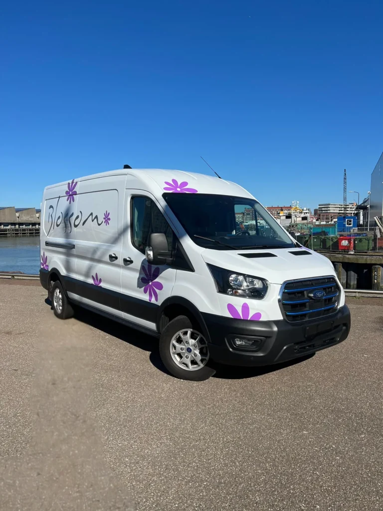 Bestelbus van Blossom met belettering en paarse bloemen